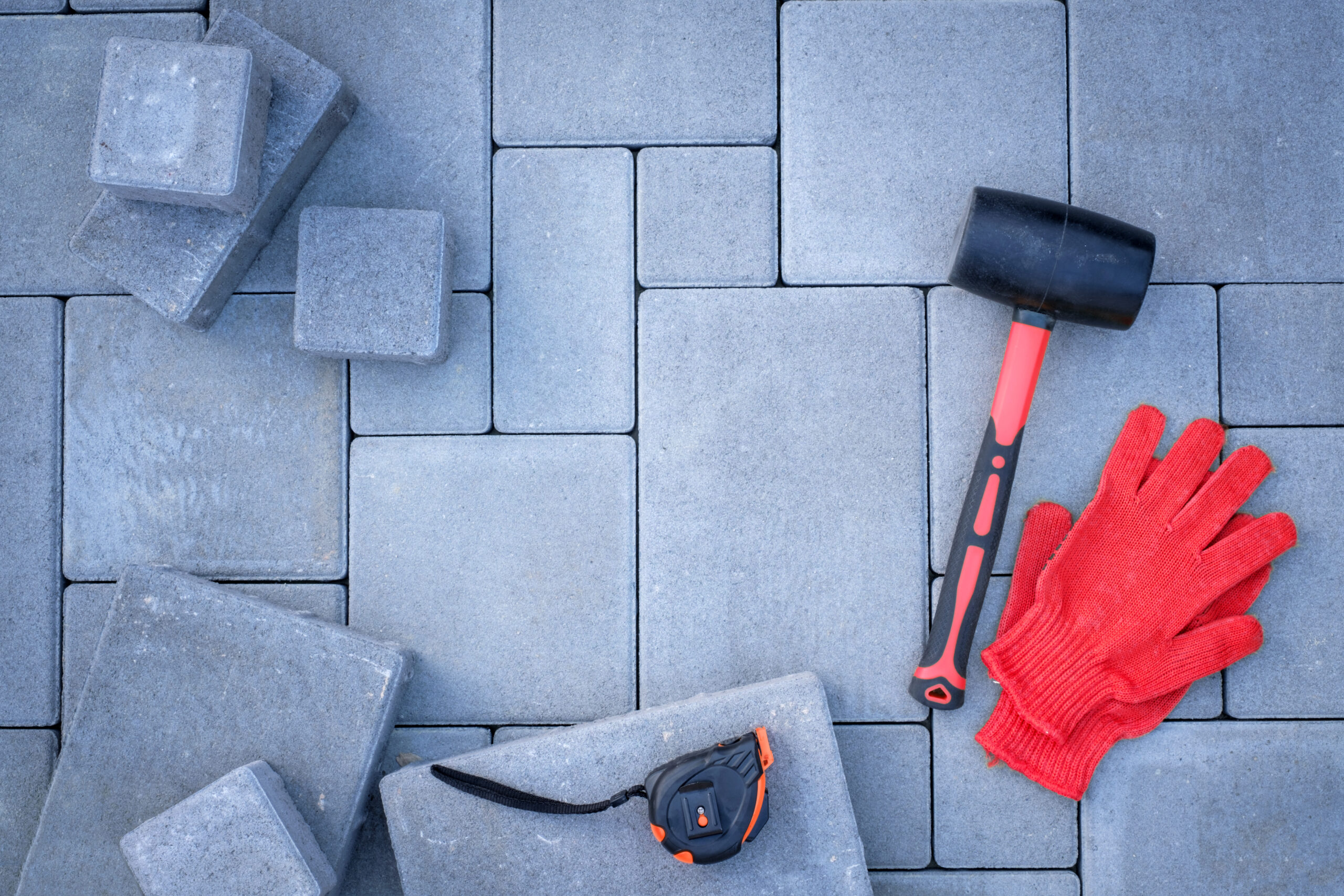 Paving stones paving background. Installing tools on foreground